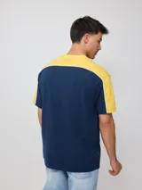 Remera negra de algodón con corte en hombros y mangas, cuello redondo gris oscuro y ribete blanco en los hombros. Estampado frontal con el texto "RUSTY" en tipografía futurista blanca con borde gris.