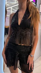 Pollera corta negra de tul con lentejuelas brillantes, diseño de tiro bajo y corte ajustado.