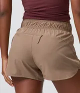 Bermuda deportiva Get Over modelo runner color beige, con cintura elástica, bajo redondeado y aberturas laterales. Cuenta con un pequeño bolsillo funcional trasero.