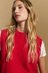 Chaleco tejido de punto en color azul marino, con diseño de textura sutil en relieve, escote redondo y terminaciones acanaladas en cuello, sisas y ruedo.