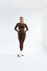 Remera deportiva de manga larga, color marrón, con cuello redondo y diseño ajustado al cuerpo.