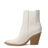 Botas tipo chelsea de caña media, color marfil, con punta fina y taco cuadrado de madera. Presentan paneles laterales elásticos al tono.