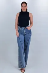 Pantalón jean wide leg de tiro alto en color azul, con diseño de costuras diagonales contrastantes en el frente y corte amplio en las piernas.