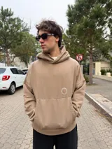 Buzo canguro oversize de algodón, color azul oscuro, con capucha y diseño gráfico circular estampado en la espalda con la inscripción VCP CONCEPTS STUDIO.