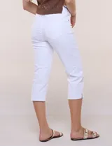 Pantalón capri blanco de tiro alto en denim elastizado, con cintura elástica ancha, bragueta simulada, bolsillos delanteros curvos y aberturas en los laterales del bajo.