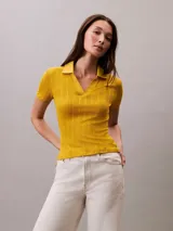 Chomba de punto pointelle texturizado color amarillo, con cuello tipo Johnny abierto, manga corta y ribetes en canalé. Presenta un diseño minimalista con logo bordado sutil en la parte frontal.