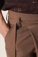 Pantalón de corte relajado confeccionado en tejido fluido con mezcla de viscosa y lino. Presenta un diseño cruzado en la cintura con cierre de cremallera, botón y trabilla ajustable. Cuenta con bolsillos laterales y bolsillos traseros de vivo con botón.