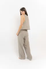 Pantalón de algodón color verde oliva, de corte recto y tiro alto con elástico en la parte trasera de la cintura. Presenta bolsillos laterales y un bolsillo trasero con tapa.