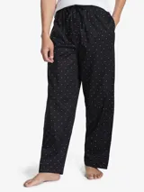 Pantalón de pijama largo negro con estampado de logos de Tommy Hilfiger en blanco y rojo. Tiene cintura elástica con cordón ajustable.