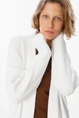 Saco abierto de punto color blanco, con diseño de textura cuadriculada en las mangas y corte holgado.