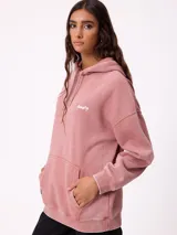 Canguro oversize color negro con efecto lavado, capucha y estampa gráfica en la espalda con tipografía desgastada y detalles en color turquesa.