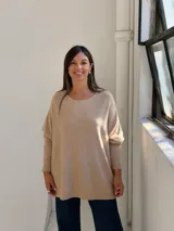 Sweater de punto color beige, con cuello redondo, mangas largas con puños acanalados y diseño holgado.