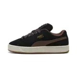 Championes Puma modelo Suede XL Wild, color negro y chocolate, confeccionados en gamuza con cordones anchos de estampado animal print, suela gruesa y detalles dorados.