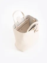 Cartera tipo tote bag pequeña de cuero vacuno negro con diseño de abejas grabadas en bajo relieve. Cuenta con doble asa de mano, correa ajustable y un tag colgante con dije metálico en forma de abeja.