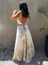 Vestido largo verde con diseño estampado tipo tie-dye y detalles dorados, de corte fluido, un solo hombro y diseño amplio.