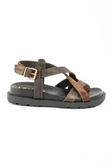 Sandalias de cuero marrón con tiras cruzadas en el empeine, suela chunky negra y hebilla metálica de ajuste en el talón.