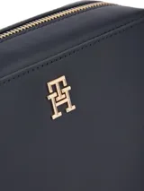 Cartera cruzada tipo bandolera Tommy Hilfiger de poliuretano color azul marino, con correa ajustable y logo metálico dorado en el frente.