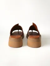 Sandalias marrones de cuero texturizado con diseño de tira ancha en el empeine y separación para el dedo, taco cuadrado bajo y suela plataforma.