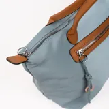 Bolso tipo tote bag color gris azulado con detalles en marrón. Tiene doble asa de hombro marrón, cierre superior y bolsillo frontal con cierre.