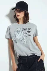 Remera blanca de manga corta con estampado gráfico de un gato marrón y un ratón, y la frase "Full of Joy" en amarillo.