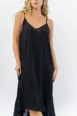Vestido negro midi con tirantes finos y escote en V. Diseño fluido con bajo asimétrico.