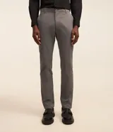 Pantalón slim de sarga color beige, de corte ajustado, con cierre frontal de botón y cremallera, y bolsillos laterales tipo cuchillo.