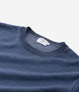 Remera de manga corta color azul con cuello redondo y detalles contrastantes en el ruedo de las mangas y el bajo. La parte delantera es lisa y la espalda presenta un estampado grande con diseño centralizado de elementos marinos.