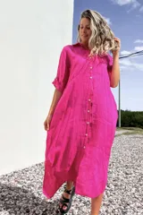 Vestido camisero midi de lino color fucsia, con cuello camisero, mangas 3/4 y cierre frontal con botones.