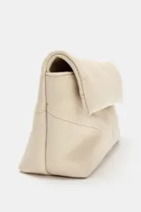 Bolso de mano tipo sobre en color beige, con diseño acolchado y solapa frontal. Cuenta con cierre imantado, bolsillo interior y correa bandolera extraíble.