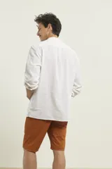 Camisa de lino color salmón con cuello mao, manga larga y bolsillo de parche en el pecho.