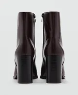 Botín de efecto piel color bordó, con punta fina, tacón ancho y cierre lateral con cremallera.