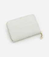 Billetera grande color negro, con cierre de cremallera perimetral y panel frontal acolchado con diseño de rombos. Presenta una placa metálica dorada en el centro y un dije colgante triangular dorado unido a la cremallera.