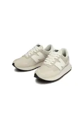 Championes New Balance modelo Course, color beige claro con logo "N" en blanco. Presentan una silueta deportiva retro con puntera y talón reforzados en gamuza.