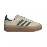 Championes adidas Gazelle Bold de diseño urbano con plataforma, confeccionados en gamuza color beige con las icónicas tres tiras laterales en verde oscuro. Presentan detalles en cuero en el talón y suela de goma con relieve.