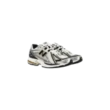 Championes New Balance modelo 1906R, color blanco con detalles plateados, negros y dorados, con diseño técnico de malla y superposiciones sintéticas, y tecnología de amortiguación N-ergy.