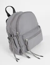 Mochila mediana de nylon color negro, con compartimento principal y bolsillo frontal con cierre. Incluye tiradores de cierre largos tipo cordón con nudos decorativos.