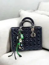 Llavero con aro metálico plateado, colgante de plástico verde con inscripción "ID CASE" y fecha, cordones amarillo y turquesa, dije de conejo de peluche con zanahoria y cordón blanco y negro.