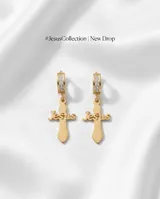 Caravanas de acero dorado con diseño de cruz que incorpora la palabra 'Jesus' en el centro. Cuentan con un aro tipo argolla decorado con pequeñas piedras brillantes.