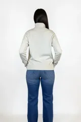 Polera de cuello alto en color beige, confeccionada en tejido de punto suave, con corte recto y detalle de tajo lateral en el ruedo.