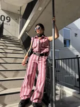 Pantalón de denim estilo wide leg con diseño de rayas verticales en tonos rosados y blancos.