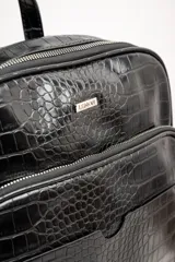 Mochila negra de cuero vegano con textura croco, tamaño mediano, con doble compartimento con cierre y correas ajustables.