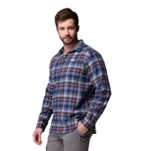 Camisa de franela de manga larga, con estampado a cuadros en tonos azul marino, naranja y blanco, cierre frontal de botones y un bolsillo en el pecho con botón.