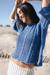 Buzo azul de lino 100% tejido a mano con diseño de trenzas. Tiene cuello redondo, mangas 3/4 y corte holgado.