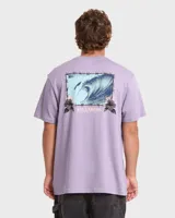 Remera Billabong de manga corta color lila, con gran estampado gráfico en la espalda que muestra una ola dentro de un marco de alambre de púa con flores y el logo de la marca.