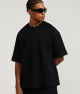 Remera oversize de manga corta y cuello redondo, color negro, con diseño liso y corte holgado.