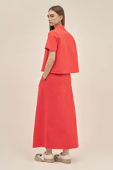 Camisa color coral de tejido seersucker texturizado, con cuello camisero, manga corta y cierre frontal con botones nacarados.