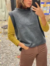 Chaleco de paño de lana gris con cuello alto y diseño sin mangas, de corte recto y holgado.