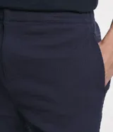 Bermuda de hombre, corte slim, color blanco con textura visible. Confeccionada principalmente en lino y algodón, con un pequeño porcentaje de elastano para mayor ajuste. Presenta cintura elástica y bolsillos laterales.