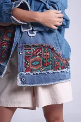 Campera de jean celeste con apliques de patchwork con motivos geométricos en hombros y bolsillos.