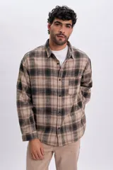 Sobrecamisa de franela a cuadros en tonos tostado y negro, de manga larga, con cierre frontal de botones y un bolsillo aplicado en el pecho.